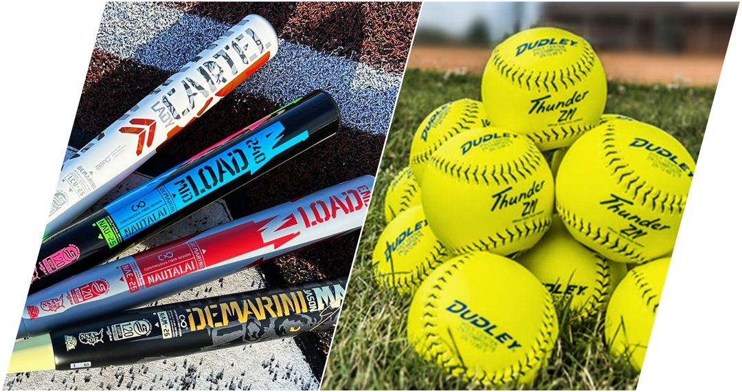Five colorful softball bats laid on the ground next to a pile of bright yellow Dudley Thunder softballs stacked on grass, with a baseball field in the background.