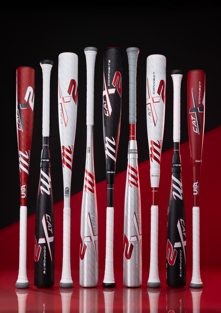 Eight 2025 Marucci CATX2 (-3) BBCOR Baseball Bats (MCBCX2) stand upright against a red and black background, showcasing white, black, red, and silver designs, Marucci branding, and anti-vibration tech for comfort.