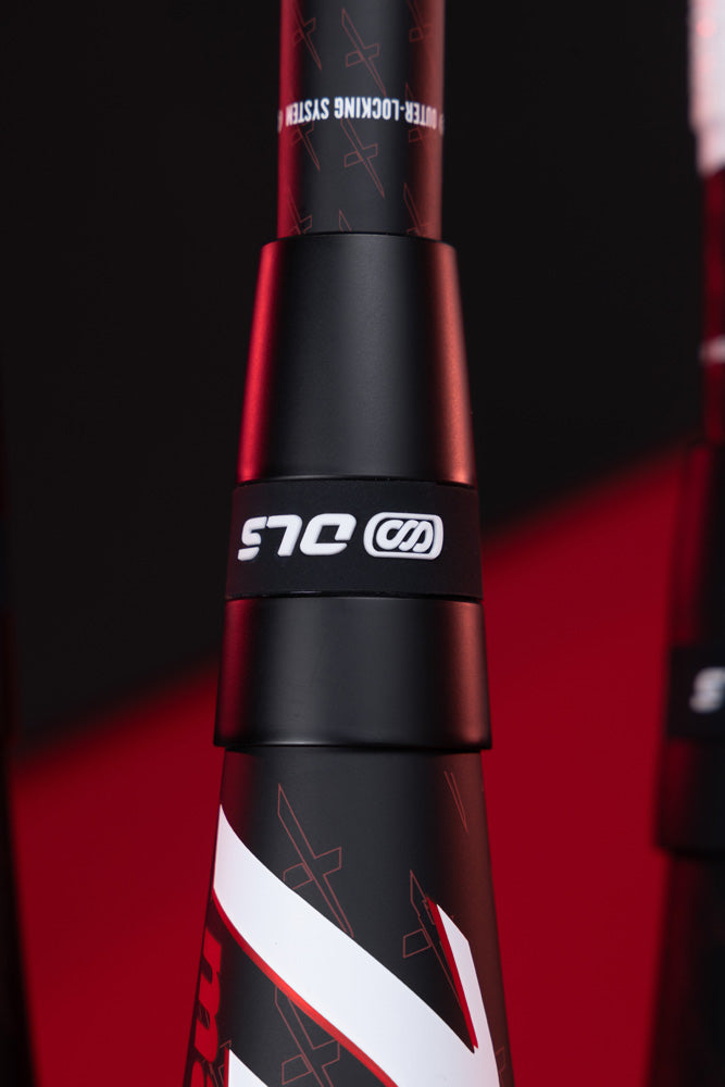 Close-up of a black and red Marucci 2025 CATX2 Composite (-10) USA Baseball Bat with the white OJS logo and white diagonal stripes, set against a blurred red and black background. Features may include Anti-Vibration Technology.