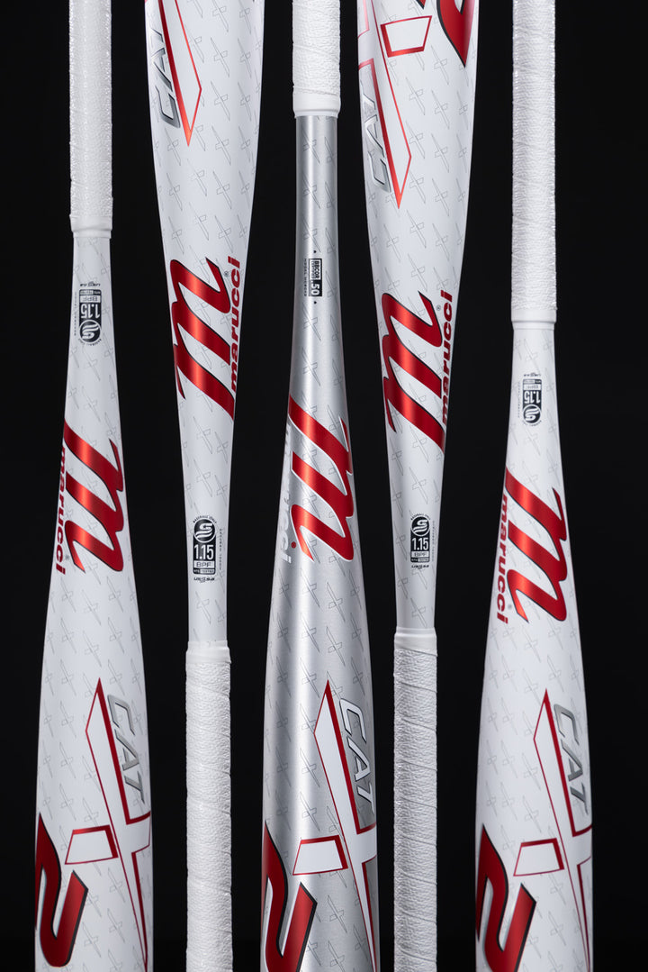 Five Marucci 2025 CATX2 (-3) BBCOR Baseball Bats (MCBCX2) stand upright against a black background, displaying their white and silver finish, red and black logos, and one-piece alloy construction.