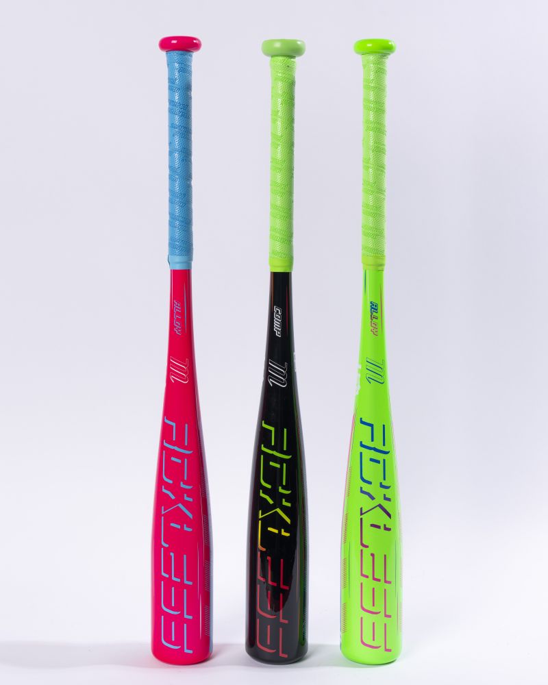Three Marucci 2027 RCKLESS (-11) 2 5/8″ USA Tee Ball Baseball Bats (model MTBR2) stand upright side by side. The bats feature modern designs in pink with a blue grip, black with a green grip, and neon green with a green grip. Each bat showcases Ring-Free Barrel Construction for maximum performance and durability and is USA Baseball certified. The bats are displayed against a plain white background.