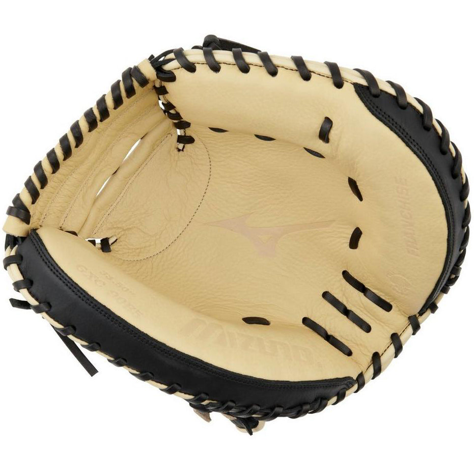 A close-up of the Mizuno Franchise 33.5" Catcher's Mitt (GXC90B5) showcases its tan and black full-grain leather construction, inner padding, precise stitching, and the Mizuno logo on the palm.