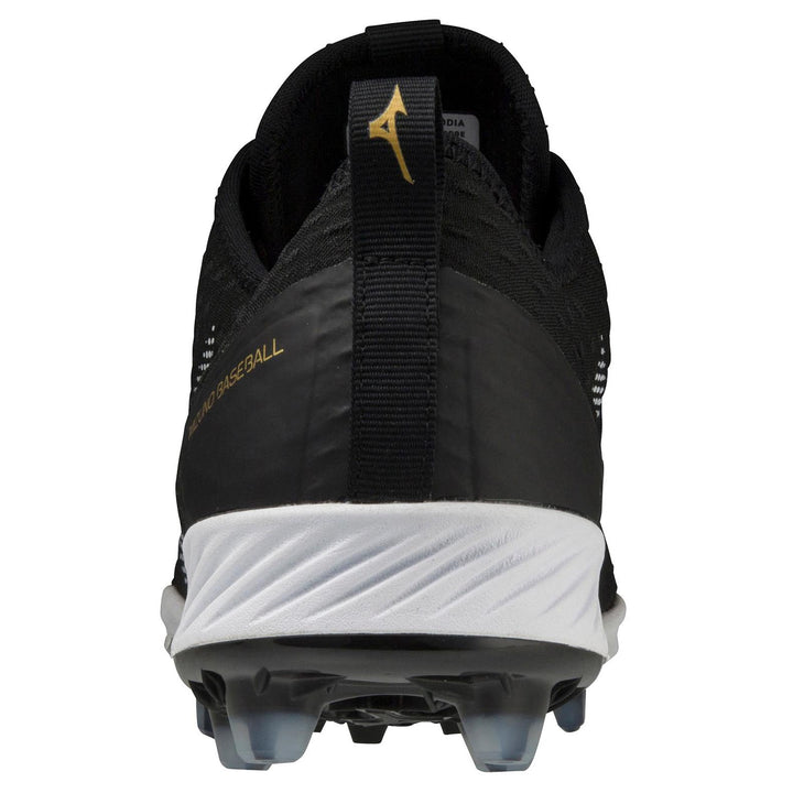 Rear view of the Mizuno Dominant 4 Men's TPU Molded Baseball Cleats (320670) shows a white sole, clear cleats, gold Mizuno Baseball text on the side, and a black heel pull tab with a gold Mizuno logo at the top.