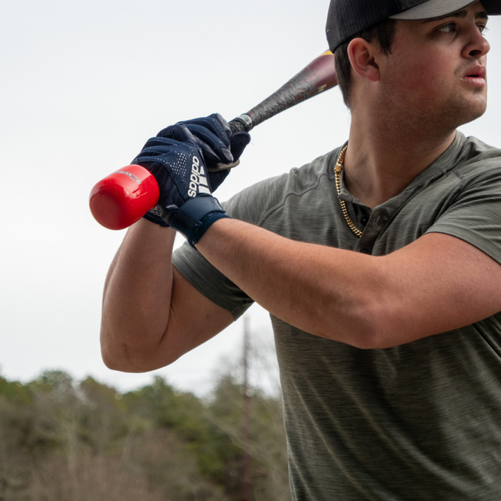 A man holding a baseball bat with the Hitting Knob Bat Weight by Hitting Knob, designed to boost bat speed and serve as an effective baseball hitting aid.