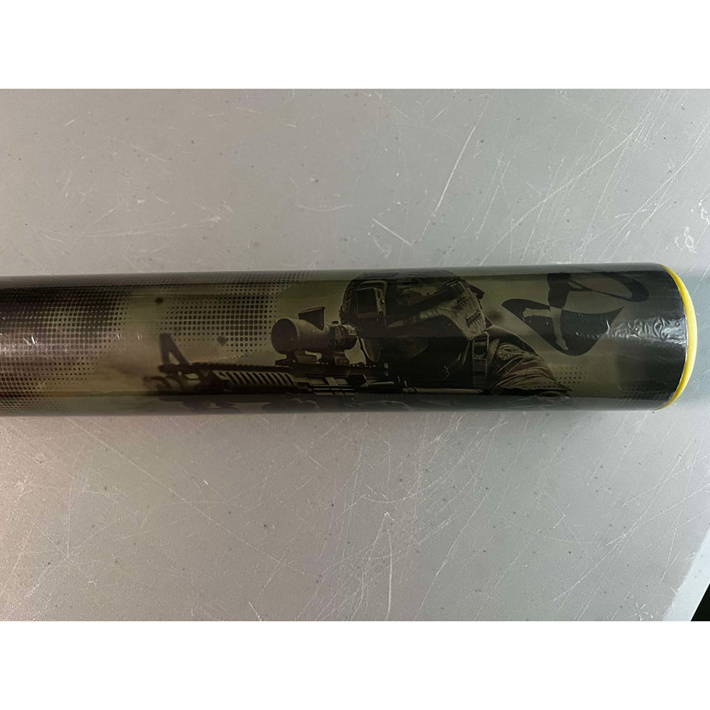 The Pure Sports 2025 Hellfire X22 13″ Endload USA Softball Bat (5135M565) features a soldier in tactical gear aiming a rifle on a gray background, with a distinctive yellow rim at the end.