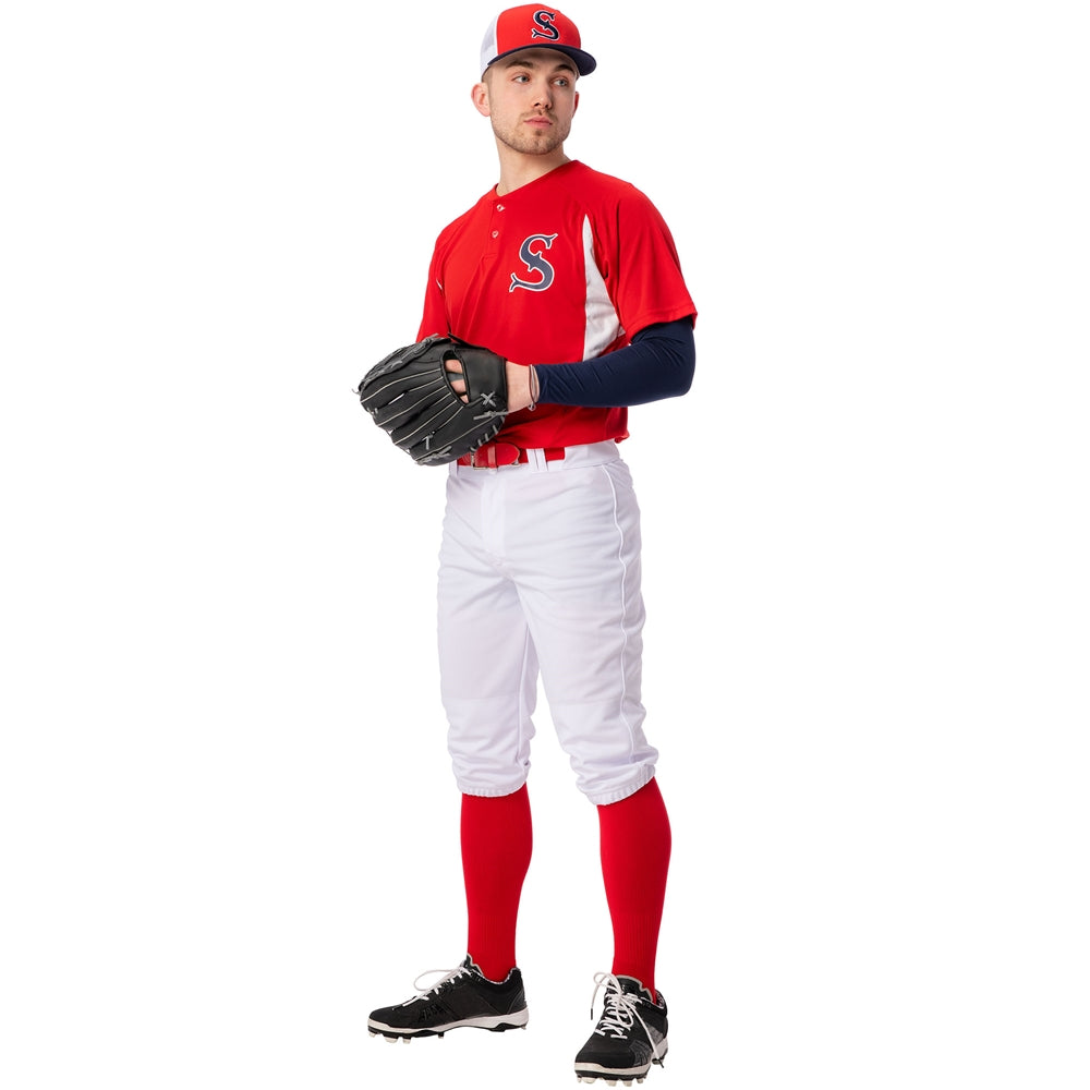 A baseball player in Champro Sports Champro Adult Triple Crown 2.0 Knicker Baseball Pants (BP68), a red jersey with a white S, red socks, black cleats, and a red and gray cap stands holding a black glove, looking to the side.