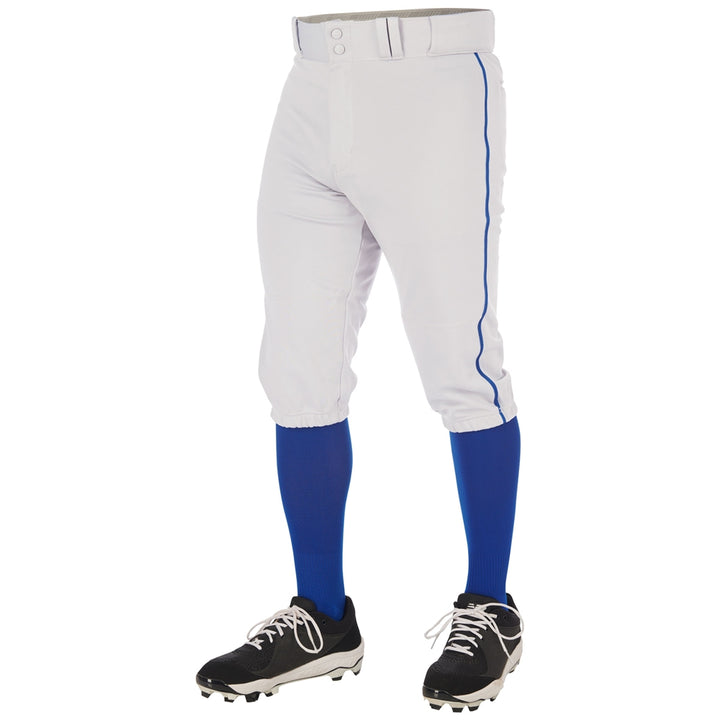 A person wearing Champro Sports Youth Triple Crown 2.0 Knicker Baseball Pants with Piping (BP70Y), blue knee-high socks, black cleats, and a white belt, shown from the waist down against a white background.