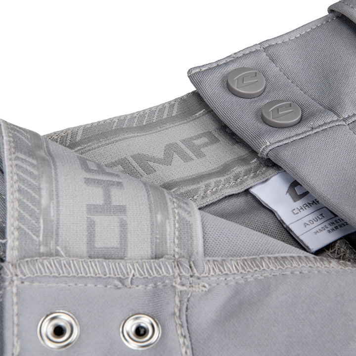 Close-up of gray Champro Youth Triple Crown 2.0 Knicker Baseball Pants with Piping (BP70Y) by Champro Sports, featuring a branded waistband, logo snap buttons, stitched seams, metal grommets, and an interior tag with care instructions.