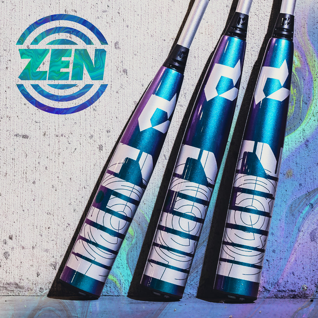 Three metallic blue and purple 2026 DeMarini ZEN Oil Slick (-10) USSSA Baseball Bats with bold white graphics lean against a concrete wall, beside a circular “ZEN” logo, highlighting their advanced Dark Matter Composite barrel design.