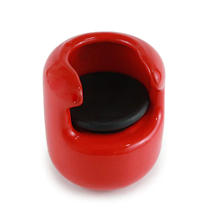 A small, glossy red ceramic ashtray with a rounded shape, black circular base insert, and two rim notchesāideal for holding cigarettes or resting your Hitting Knob Bat Weight by Hitting Knob between practice swings.