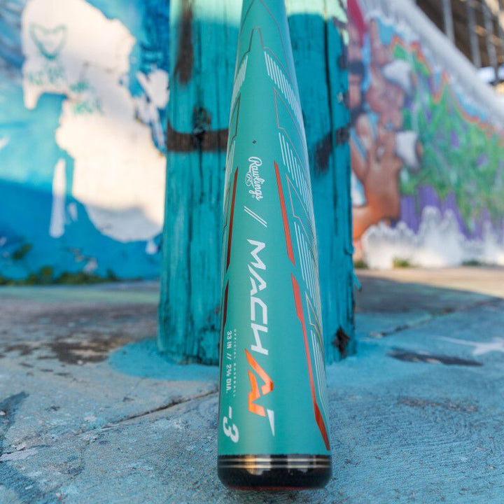 A 2024 Rawlings Mach AI (-3) BBCOR Baseball Bat: RBB4MC3 (USED) rests on a concrete surface.