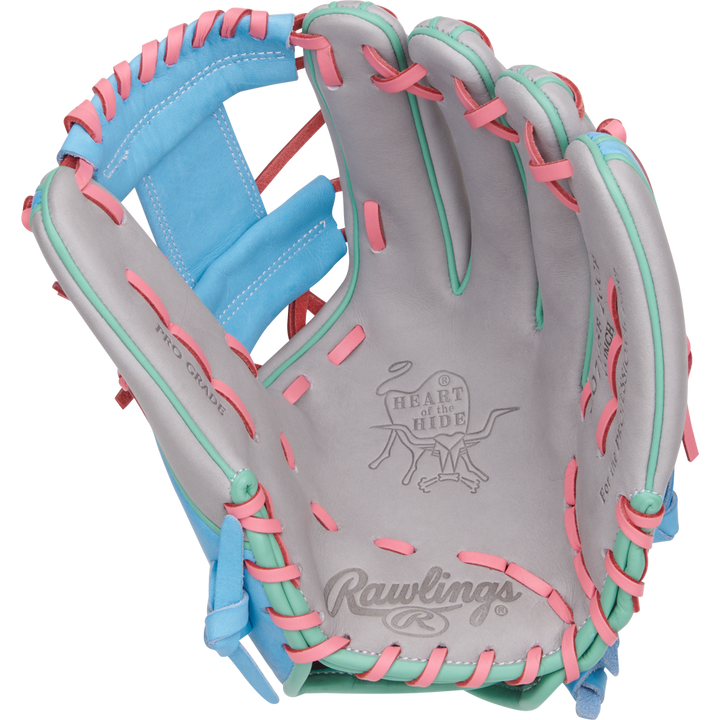 The Rawlings Heart of the Hide 12" Fastpitch Glove (PRO716SB-2GCB) features gray leather, pink and teal laces, blue accents, and displays the iconic Rawlings logo and Heart of the Hide branding inside the open palm.