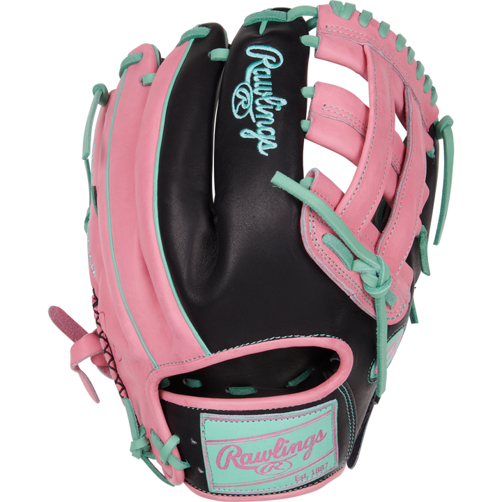 The Rawlings Heart of the Hide 12.25" Color Sync Baseball Glove (PROR207-6BP) features a black base with pink and teal accents, teal laces, a pink Rawlings logo, open webbing, and is designed for outfielders.