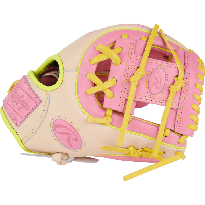 The Rawlings Heart of the Hide 11.25" Color Sync Baseball Glove (PROR312U-2P) features a beige design with pink and yellow laces and accents, plus the signature Rawlings logo.