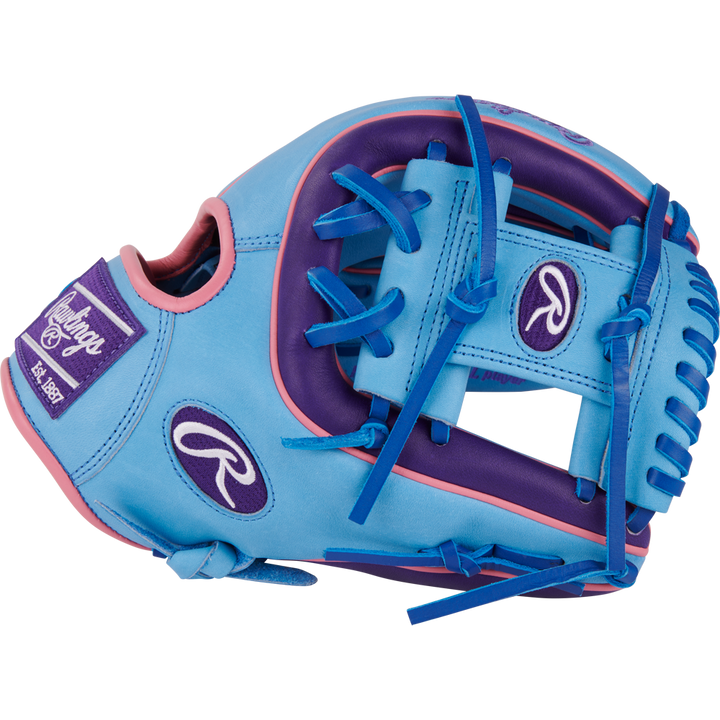 The Rawlings Heart of the Hide 11.5" Color Sync Baseball Glove (PROR314-2CBPU) is a blue and purple infield glove with pink accents, blue laces, and features the Rawlings logo plus “Est. 1887” on a patch.