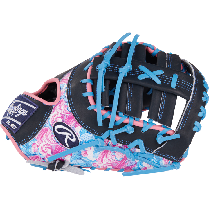 The Rawlings Heart of the Hide 13" Color Sync First Base Mitt (PRORDCT-10NSS) features a black base, blue and pink laces, swirling pink and blue thumb/palm, white stitching, and the Rawlings logo.