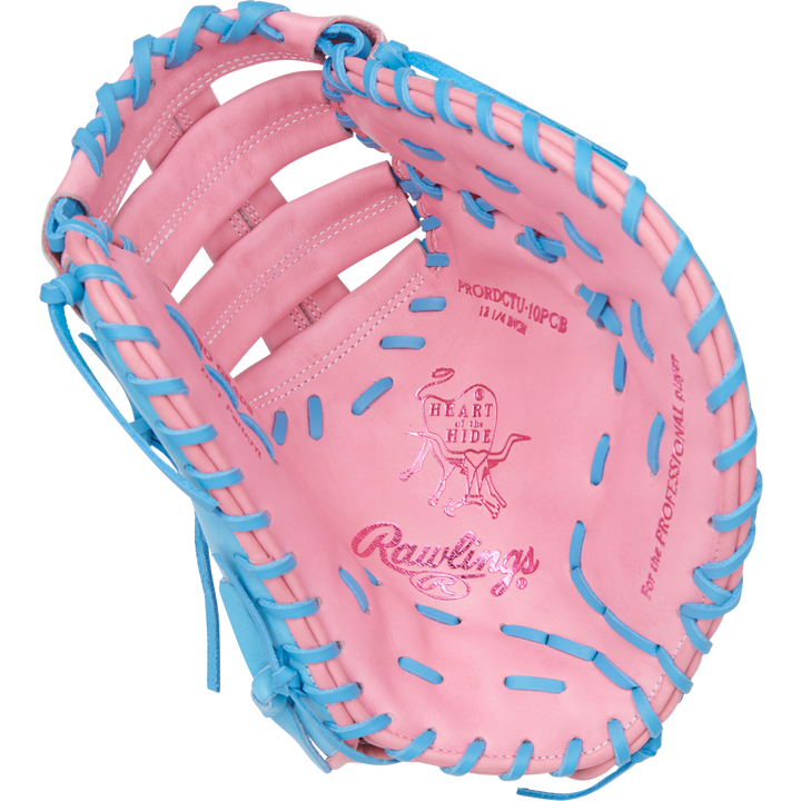 The Rawlings Heart of the Hide 12.25" First Base Mitt (PRORDCTU-10PCB) features a pink design with blue lacing, ContoUR Fit, and embossed logos on the palm—combining standout style and renowned Rawlings performance.