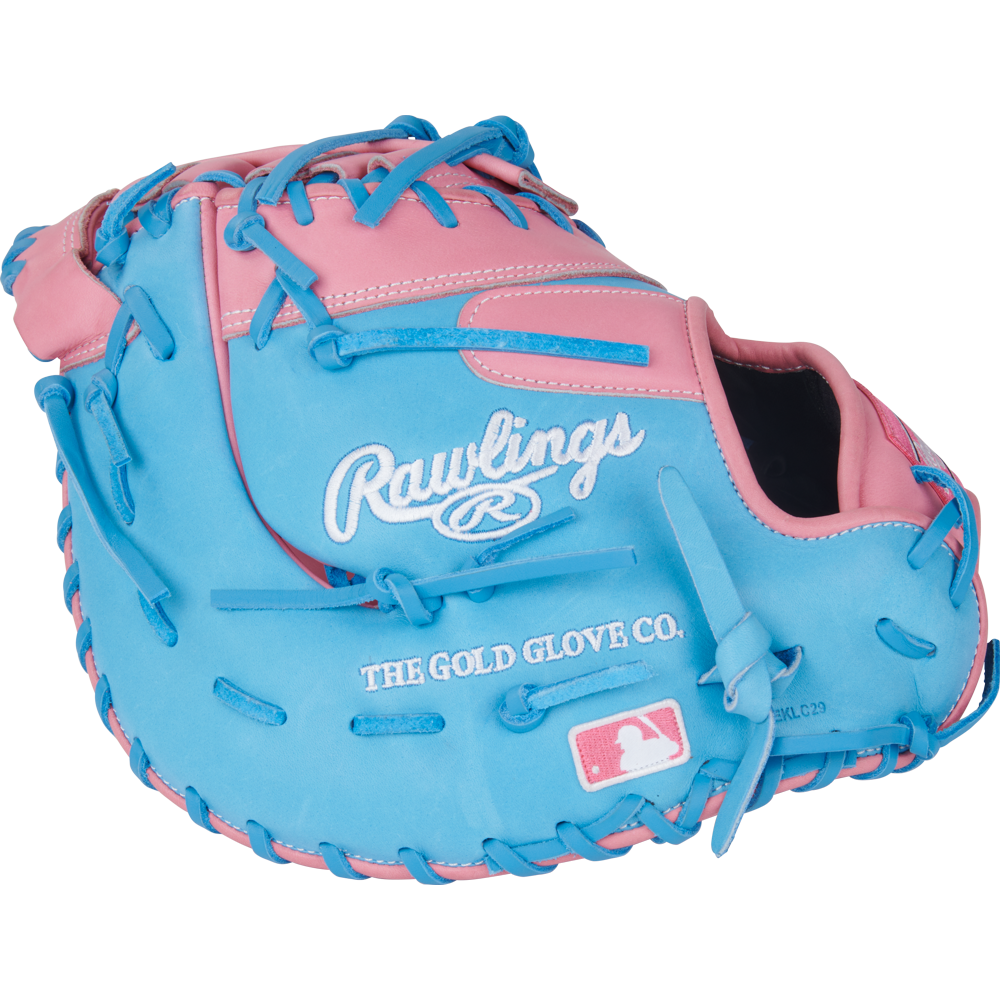 The Rawlings Heart of the Hide 12.25" First Base Mitt (PRORDCTU-10PCB) features a pink and blue design, blue laces, Rawlings branding, The Gold Glove Co. text, and an MLB logo stitched on the front.
