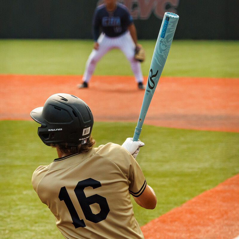 A baseball player holds the 2025 Rawlings Clout AI (-3) BBCOR Baseball Bat: RBB5C3 (USED), demonstrating the power and precision of this Rawlings one-piece BBCOR bat.
