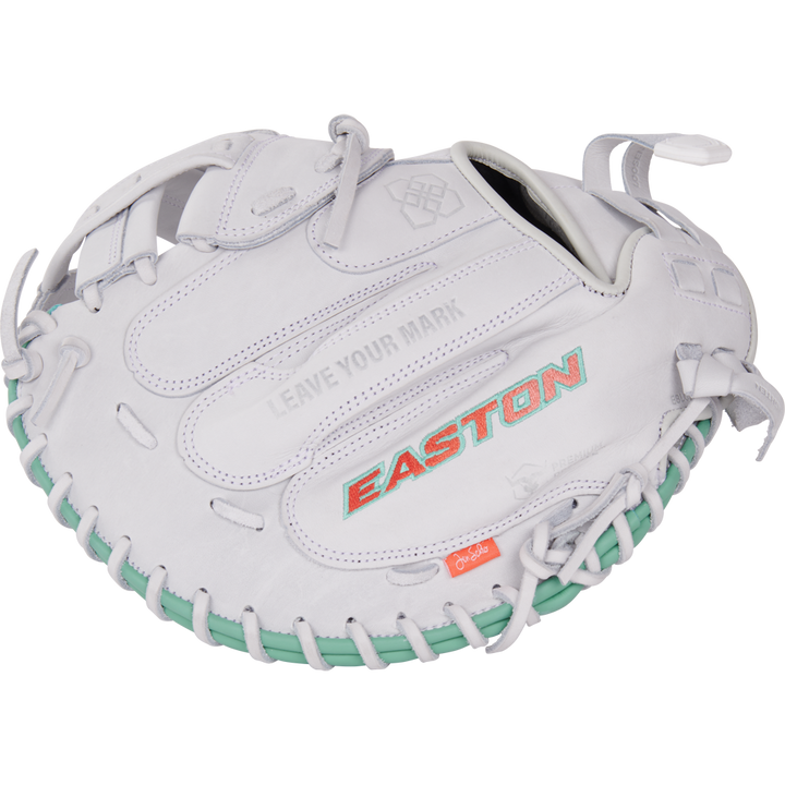 The Easton Jen Schro "The Rudi" 34" Fastpitch Catcher's Mitt (RUDI-2024) features a white design, teal lacing, red-orange EASTON branding, premium USA steerhide leather, and "LEAVE YOUR MARK" embossed above the logo.