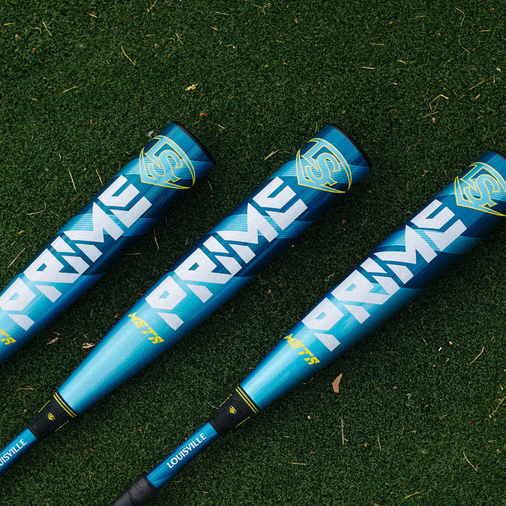 Three 2025 Louisville Slugger Meta Prime (-8) 2 3/4" USSSA Baseball Bats (WBL2971010, DEMO) lie side by side on green artificial turf.