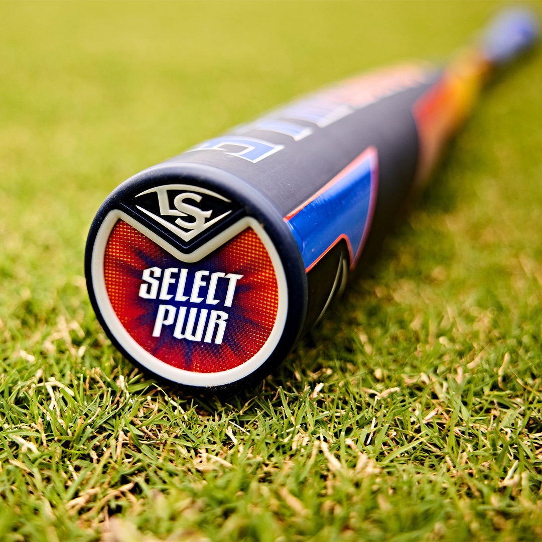 Close-up of the 2025 Louisville Slugger Select PWR (-3) BBCOR Baseball Bat (WBL2967010) resting on green grass, highlighting the EXD Premium Alloy Barrel, Select PWR end cap, and Louisville Slugger logo with a blurred background.