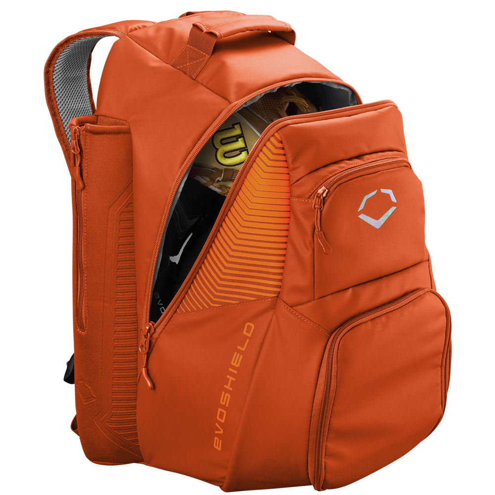 The EvoShield Tone Set Backpack (WB57304) by EvoShield is an orange, water-resistant backpack with multiple zippered compartments, bat sleeves, a top handle, padded straps, and sports gear inside like a yellow and black helmet.