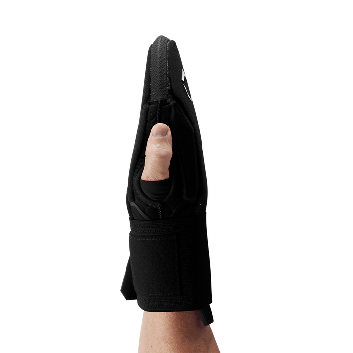 A personโs hand is shown from the side wearing the EvoShield Sliding Mitt 2.0: WB57537 by EvoShield, with straight fingers and visible thumb. The black padded mitt features a wrist strap for protection, covering the hand up to the wrist.