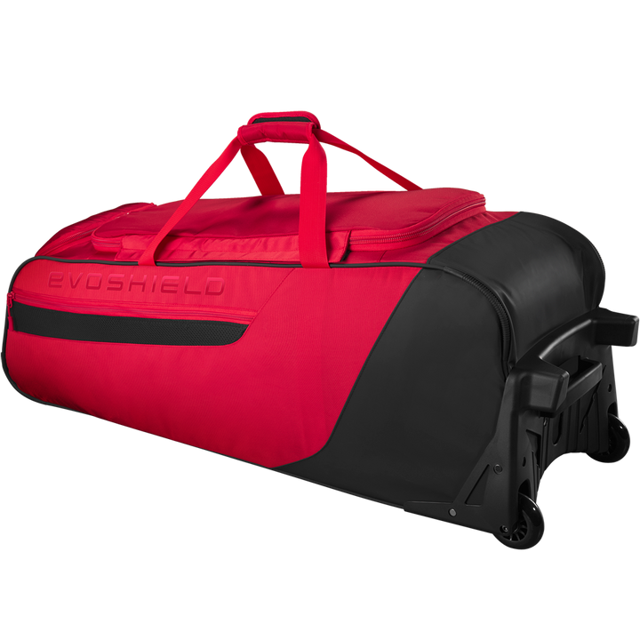 The EvoShield Takeover Wheeled Bag (WB57572) is a large red and black gear bag with sturdy wheels, a top handle, and bat sleeves—ideal for baseball gear. EvoShield branding is embossed on the side.