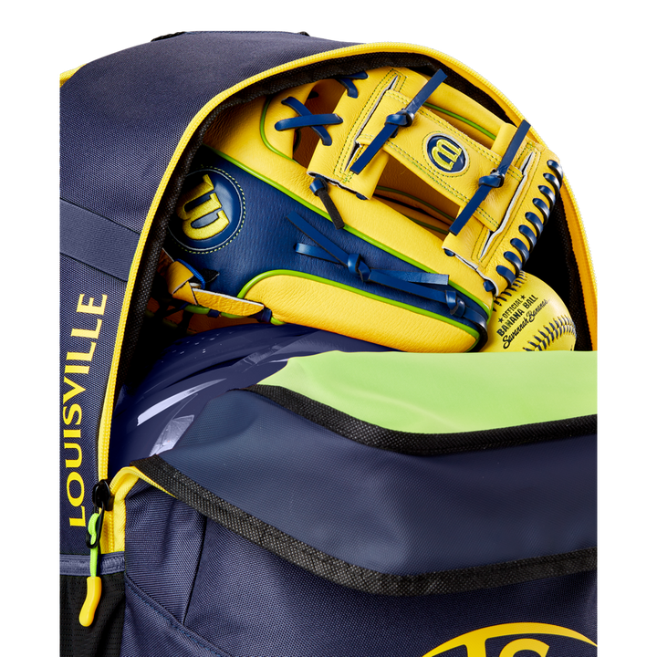 A close-up of a partially unzipped navy and yellow Louisville Slugger Savannah Bananas Powerized Stick Pack Backpack (WB57636) shows a yellow and blue Wilson baseball glove and a yellow softball inside.