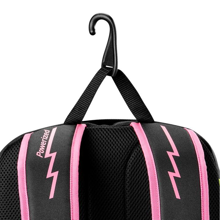 A black Louisville Slugger Party Animals Powerized Stick Pack Backpack with pink lightning bolt designs and pink-trimmed straps hangs from a black hook by its fabric loop, featuring the Louisville Slugger brand on one strap.