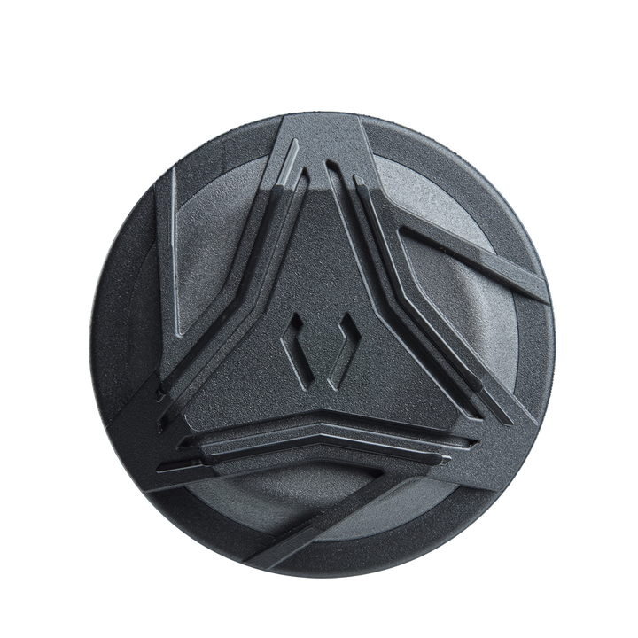 A round, dark gray object with raised angular designs—resembling the detailing of the DeMarini ZEN Limited Edition (-10) USSSA Baseball Bat (WBD2541010) by DeMarini—set against a plain white background.