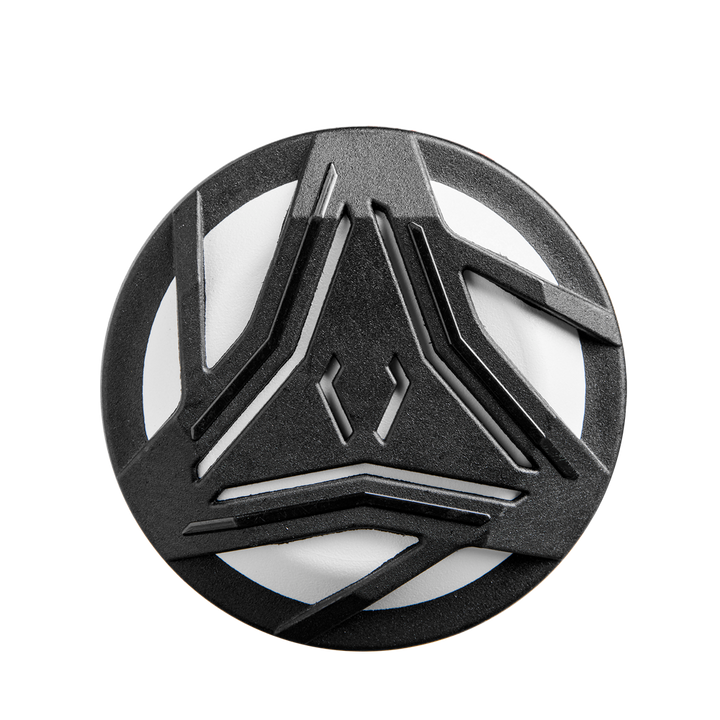 A round, black object featuring geometric cutouts reminiscent of the 2025 DeMarini Whisper (-9) Fastpitch Softball Bat (WBD2545010), its design echoing the bat's futuristic Amplified Gapped Wall Barrel pattern for a strikingly modern look.