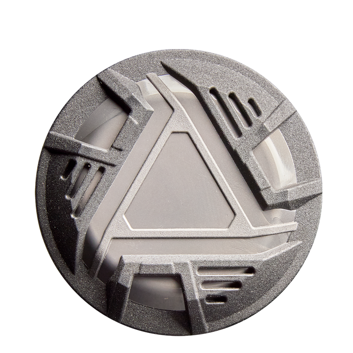 A round, metallic gray object with an angular geometric design rests on a white background, its look inspired by the advanced engineering of the 2026 DeMarini ZEN (-10) USSSA Baseball Bat by DeMarini.