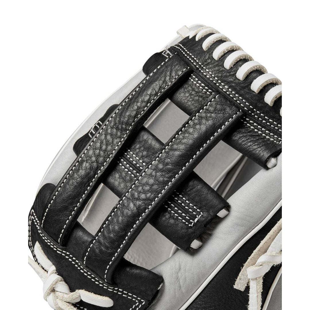 Close-up of the Wilson A1000 IF12 12" Fastpitch Glove by Wilson, showcasing its black and white leather design, detailed stitching, and distinctive webbing between the thumb and fingers.