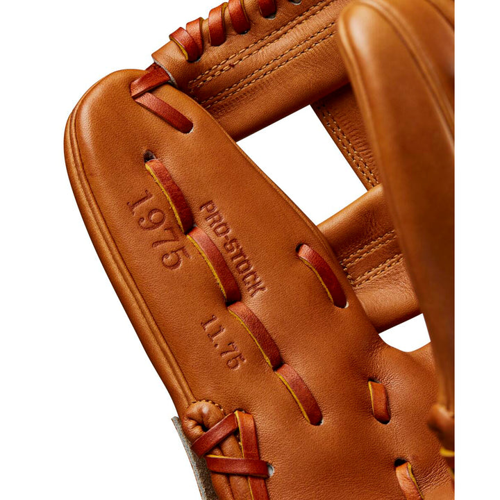 Close-up of a tan Wilson A2000 1975 11.75" Glove Day Series Baseball Glove (WBW1020761175) showing visible stitching, embossed text (PRO STOCK, 11.75, 1975), detailed Pro Stock leather texture, and laces.