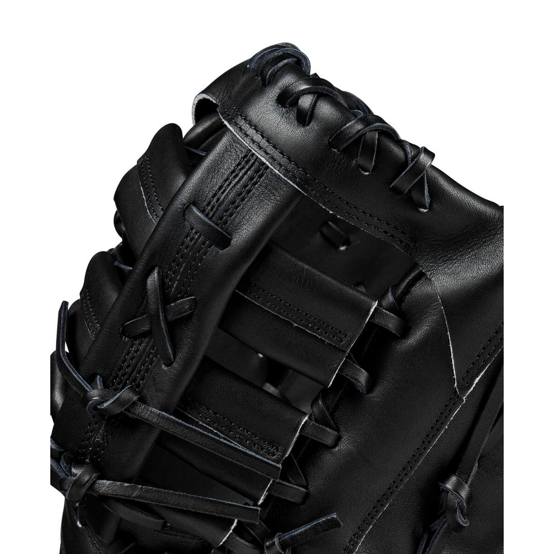 Close-up of a Wilson A2000 1679 12.5" First Base Mitt (WBW102095125), featuring black Pro Stock leather with detailed stitching and lacing on the webbing and fingers, set against a white background.
