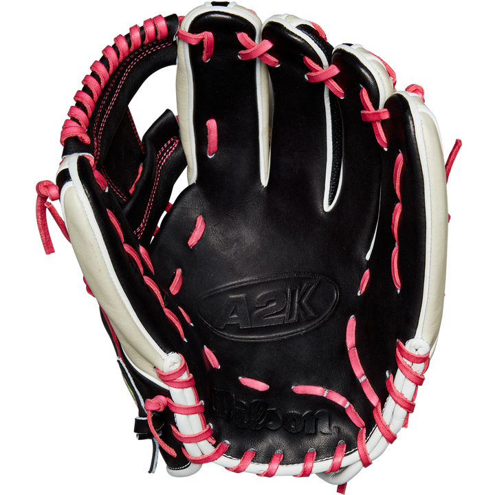 The Wilson A2K 1724 11.75" Baseball Glove (GOTM June 2024) by Wilson is shown open with black Pro Stock Select leather, white accents, and pink laces, displayed against a plain white background.