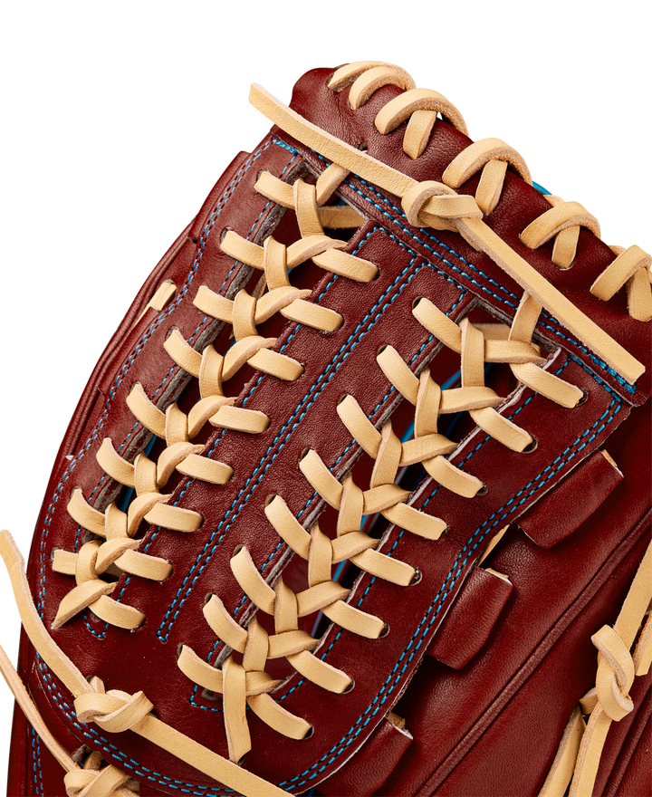 Close-up of the Wilson A2000 D33 11.75" Baseball Glove (Winter 2024) in red-brown Pro Stock leather, with tan crisscross laces and blue stitching.