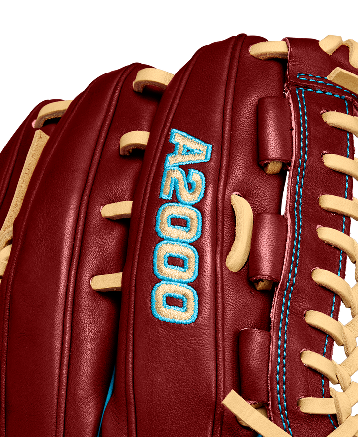 Close-up of a Wilson A2000 D33 11.75" baseball glove (Winter 2024), maroon Pro Stock leather with tan laces, blue stitching, and “A2000” embroidered in blue on the side.