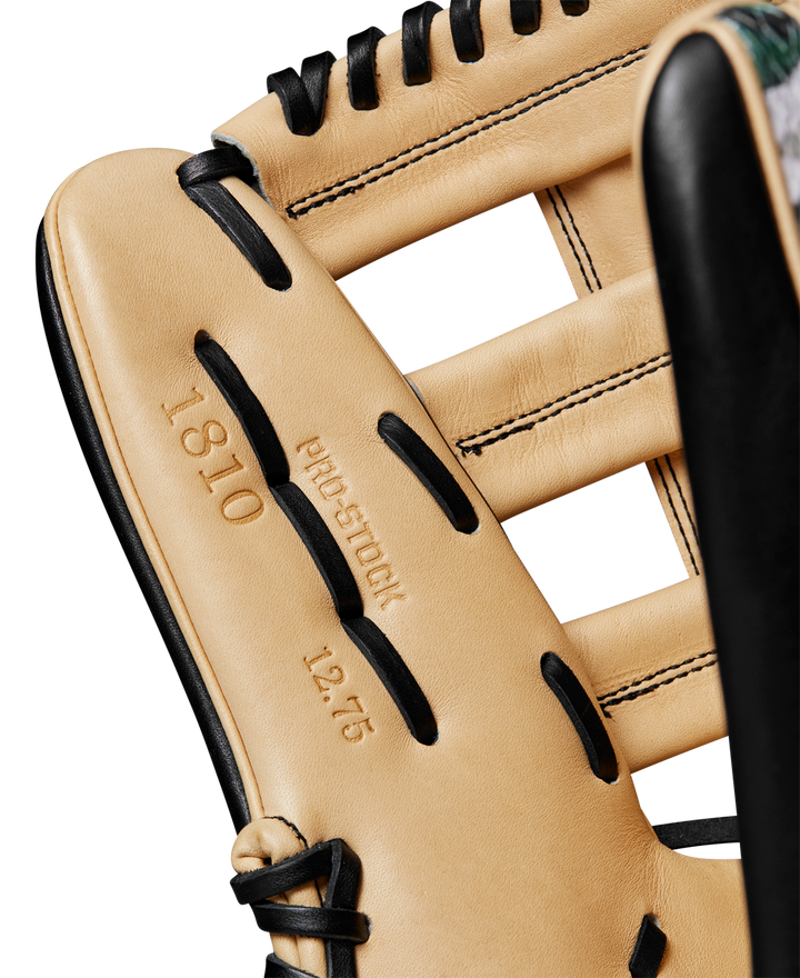 Close-up of a tan Wilson A2000 1810 12.75" Baseball Glove (WBW1025271275) with black laces, featuring embossed text "1810," "PRO STOCK leather," and "12.75" on the leather interior.