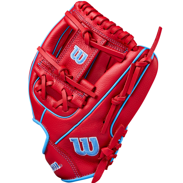 A Wilson A500 11.5" Baseball Glove (WBW102540115) in bright red with light blue accents and stitching, displaying the classic Wilson “W” logo in blue and white on the thumb and wrist, is shown upright against a plain background.