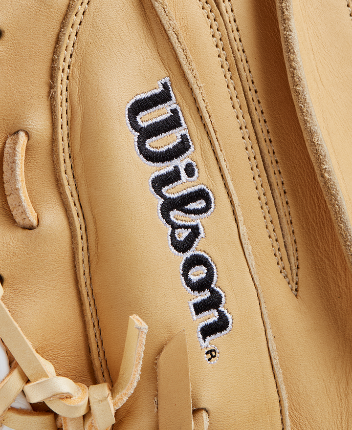 Close-up of a tan Wilson A1000 CM33 33" Baseball Catcher's Mitt (WBW10258933), showcasing full grain leather, detailed stitching, and the embroidered black and white “Wilson” logo.