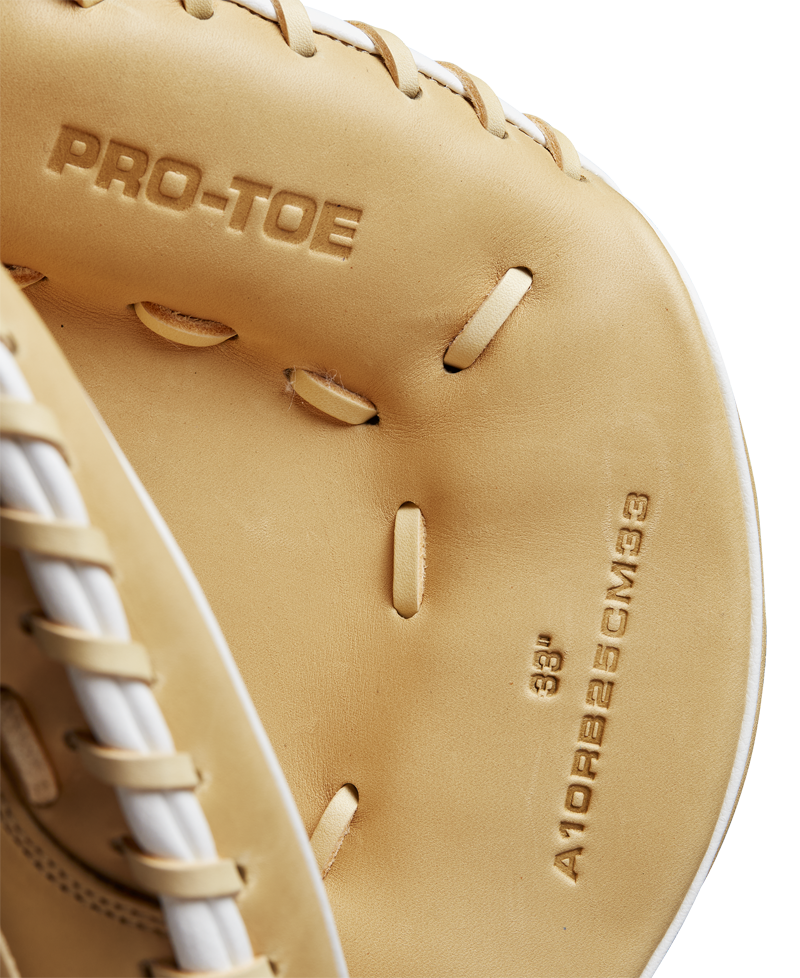 Close-up of the Wilson A1000 CM33 33" Baseball Catcher's Mitt (WBW10258933) in tan full grain leather with PRO-TOE and sizing details embossed inside. White stitching and laces are visible along the edges. Brand: Wilson.
