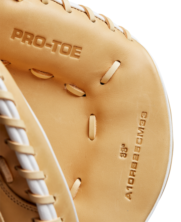 Close-up of the Wilson A1000 CM33 33" Baseball Catcher's Mitt (WBW10258933) in tan full grain leather with PRO-TOE and sizing details embossed inside. White stitching and laces are visible along the edges. Brand: Wilson.