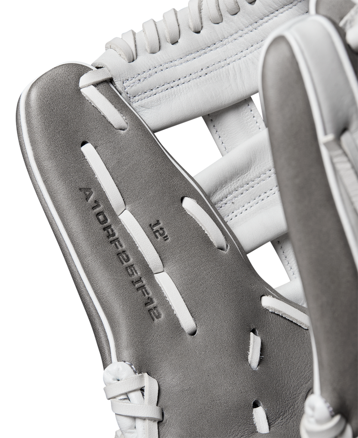 Close-up of a Wilson A1000 IF12 12" Fastpitch Glove by Wilson, featuring gray and white Full Grain leather, detailed stitching, laces, and embossed text WBW10259112 on the inside.