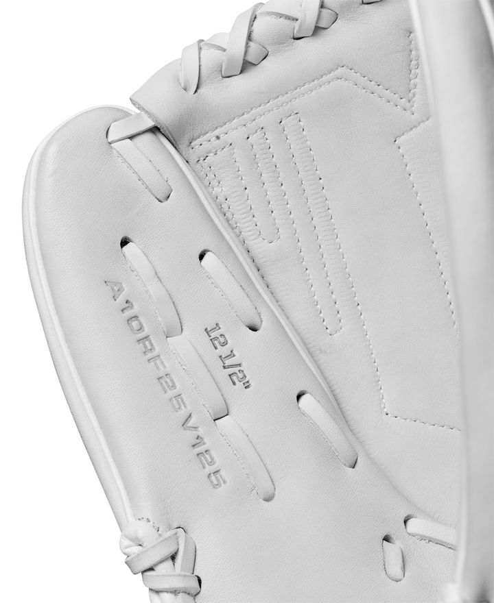 Close-up of a Wilson A1000 V125 12.5" fastpitch glove (WBW102594125) in white, highlighting detailed stitching, the brand's embossed text, and webbing on a light gray background.