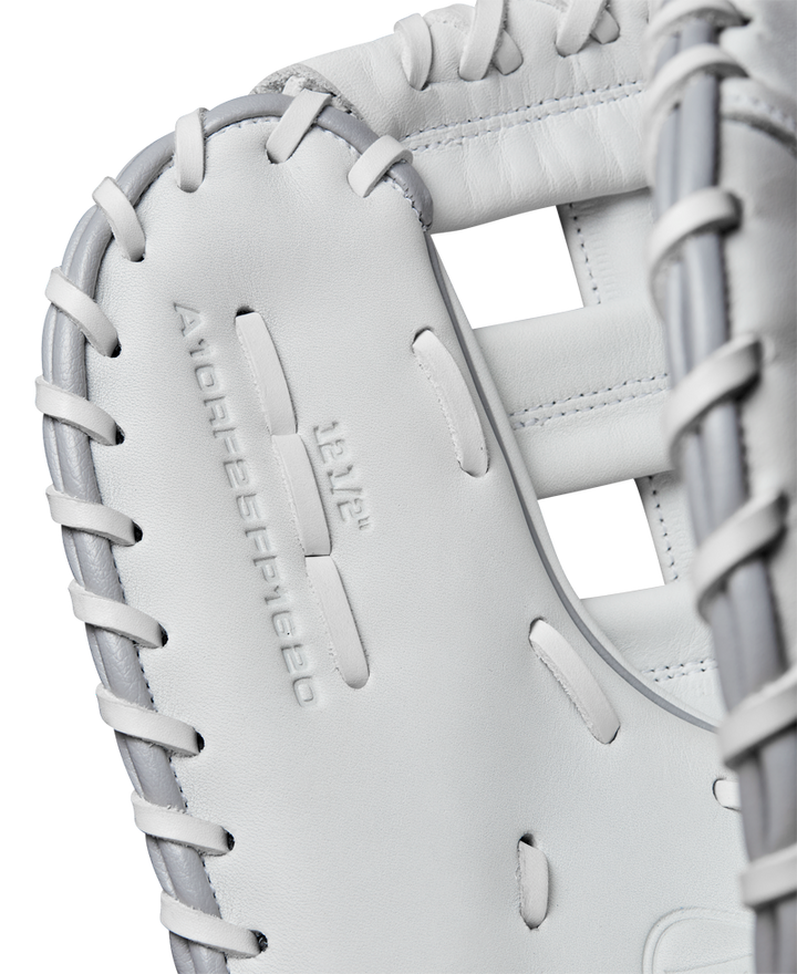 Close-up of a white Wilson A1000 1620 12.5" Fastpitch First Base Mitt (WBW102598125) in full grain leather with gray lacing, featuring embossed branding on the palm—ideal for fastpitch softball first basemen.