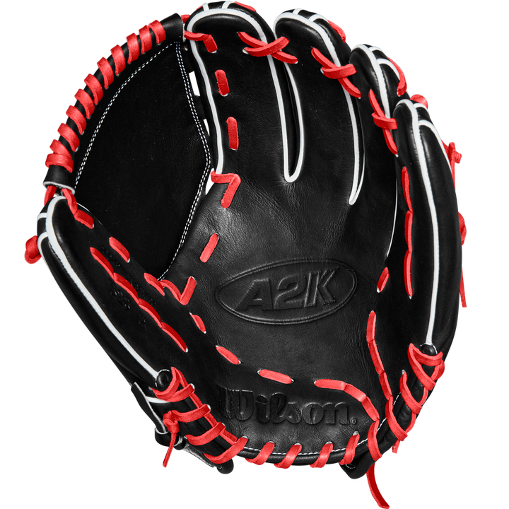 The Wilson A2K B23 12" Baseball Glove (FALL 2024: WBW10261812) by Wilson is shown open, highlighting its Pro Stock leather, black color, intricate stitching details, and striking red and white lacing.