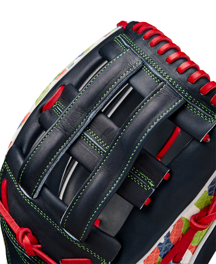 Close-up of the Wilson A2K MH23 12.75" Michael Harris GM Baseball Glove (WBW1026201275), crafted from Pro Stock Select leather in navy blue with red laces, green stitching, a floral pattern on the edge, and a woven web.
